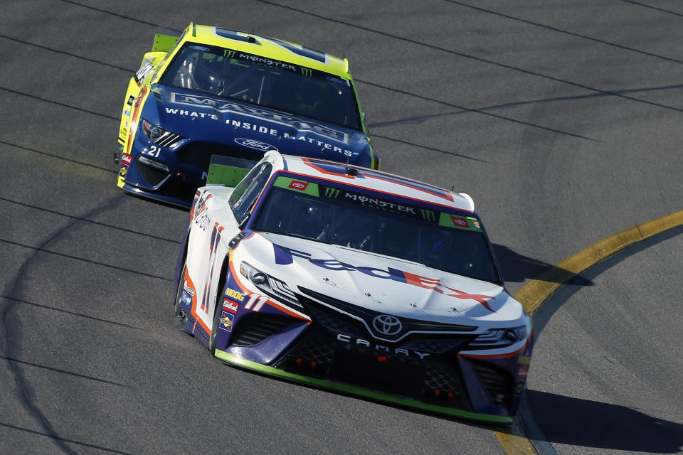 Denny Hamlin (11) drives through Turn 4 in front of Paul Menard during a NASCAR Cup Series auto race at ISM Raceway, Sunday, Nov. 10, 2019, in Avondale, Ariz. (AP Photo/Ralph Freso)