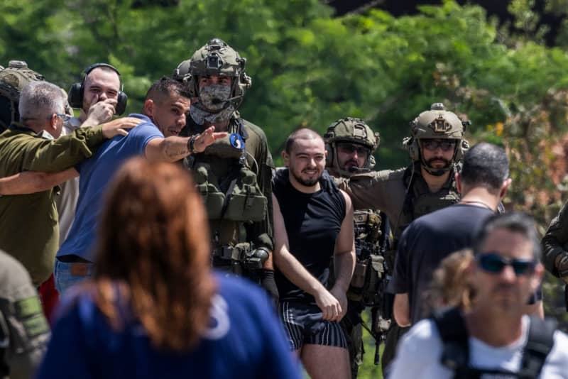 Andrey Kozlov (2nd L), 27, and Almog Meir (C), 21, two of the four Israeli hostages who were kidnapped by Hamas from the Nova music festival on 7 October, arrive by a helicopter at the Sheba Medical center in Ramat Gan. The Israel Defense Forces (IDF) said on Saturday that it had rescued four Israeli hostages in a "complex special daytime operation" in Nuseirat, a refugee camp in the central Gaza Strip. Ilia Yefimovich/dpa