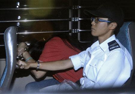 Catherine Au Yuk-shan (L), 41, a public hospital assistant, is escorted by a Hong Kong Correctional Services Department officer inside a van leaving Wanchai District Court for jail, in Hong Kong September 18, 2013. REUTERS/Stringer