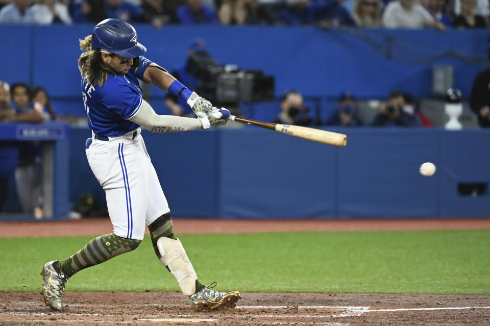 Toronto Blue Jays' Bo Bichette hits an RBI double against the Cincinnati Reds during the fifth inning of a baseball game Friday, May 20, 2022, in Toronto. (Jon Blacker/The Canadian Press via AP)