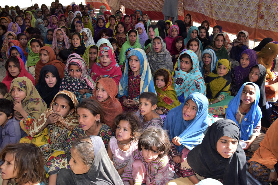 Victims of heavy flooding from monsoon rains attend class at a relief camp in Dasht near Quetta, Pakistan, Friday, Sept. 16, 2022. The devastating floods affected over 33 million people and displaced over half a million people who are still living in tents and make-shift homes. The water has destroyed 70% of wheat, cotton and other crops in Pakistan. (AP Photo/Arshad Butt)