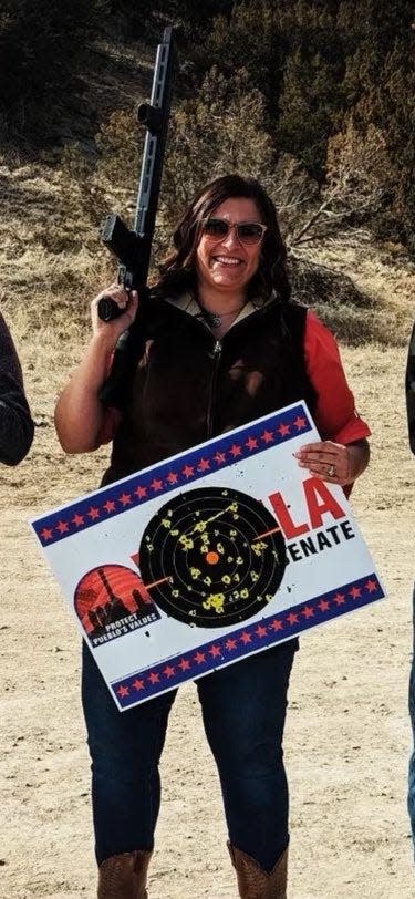 Pueblo County Democratic Party chair Bri Buentello holds a rifle and a sign for a local Republican political candidate affixed with a target for shooting practice. Buentello apologized for the incident Monday, saying her use of the signs “was in poor taste and a mistake."