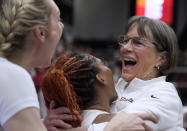 Stanford coach Tara VanDerveer, right, celebrates with Kiki Iriafen, center, and Cameron Brink, left, after the team's victory against Oregon in an NCAA college basketball game Friday, Jan. 19, 2024, in Stanford, Calif. VanDerveer tied former Duke men's basketball coach Mike Krzyzewski for the most wins as a college basketball coach. (AP Photo/Tony Avelar)