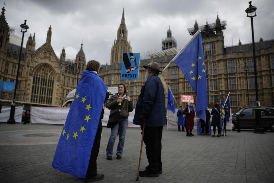 Anti-Brexit remain in the European Union supporters protest backdropped by the Houses of Parliament in London, Wednesday, April 3, 2019. After failing repeatedly to win Parliament's backing for her Brexit blueprint, Britain's Prime Minister Theresa May dramatically changed gear Tuesday, saying she would seek to delay Brexit _ again _ and hold talks with the opposition to seek a compromise.  (AP Photo/Matt Dunham)