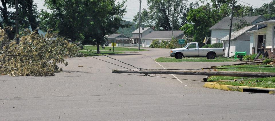 A pole and lines are still laying on a street in Holmesville.