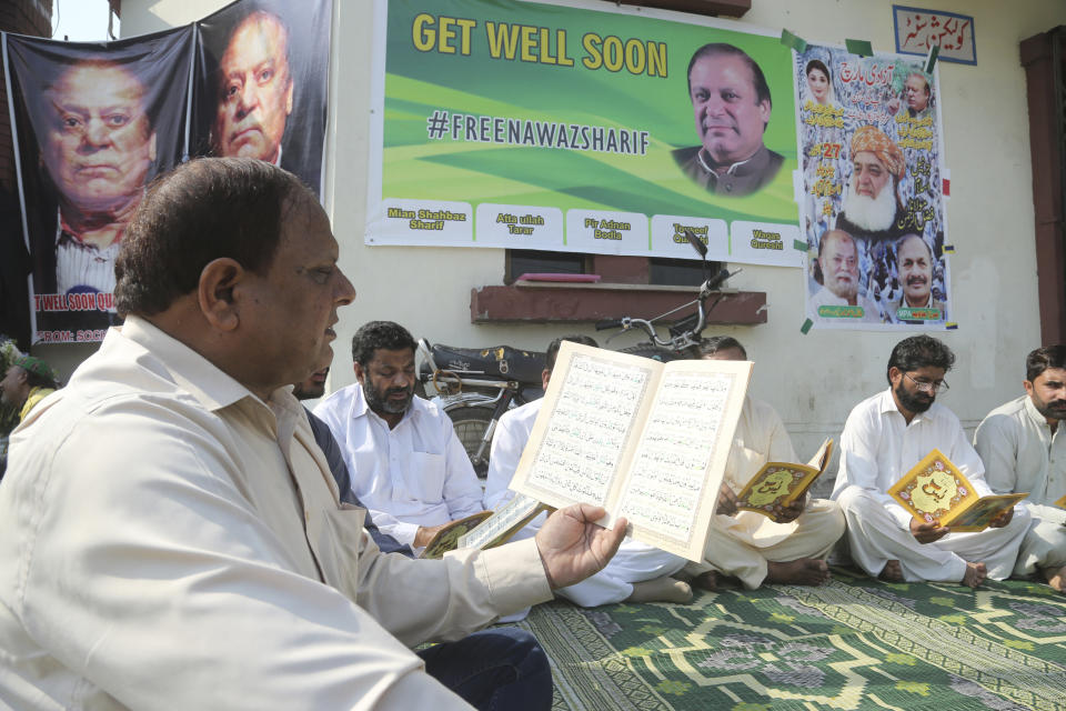 Supporters of Pakistani former Prime Minister Nawaz Sharif reads Quran for health recovery of their leader, outside a hospital where Sharif admitted in Lahore, Pakistan, Friday, Oct. 25, 2019. A top Pakistani court on Friday ordered convicted former Sharif released on bail so he can seek medical treatment at home or abroad, his family and a defense lawyer said. (AP Photo/K.M. Chaudary)