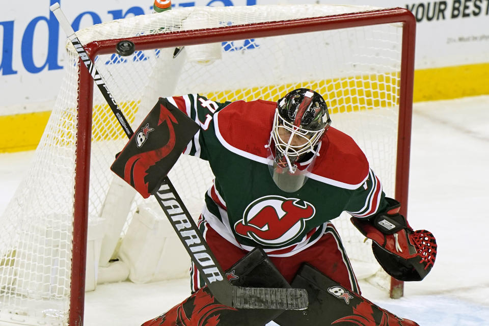 New Jersey Devils goaltender Aaron Dell deflects the puck during the second period of the team's NHL hockey game against the New York Islanders, Tuesday, March 2, 2021, in Newark, N.J. (AP Photo/Kathy Willens)