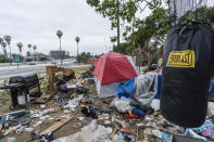 A trashed punching bag is left at a homeless encampment is seen on the side of the CA-101 highway in Echo Park neighborhood in Los Angeles Tuesday, May 11, 2021. California Gov. Gavin Newsom on Tuesday proposed $12 billion in new funding to get more people experiencing homelessness in the state into housing and to “functionally end family homelessness” within five years. (AP Photo/Damian Dovarganes)