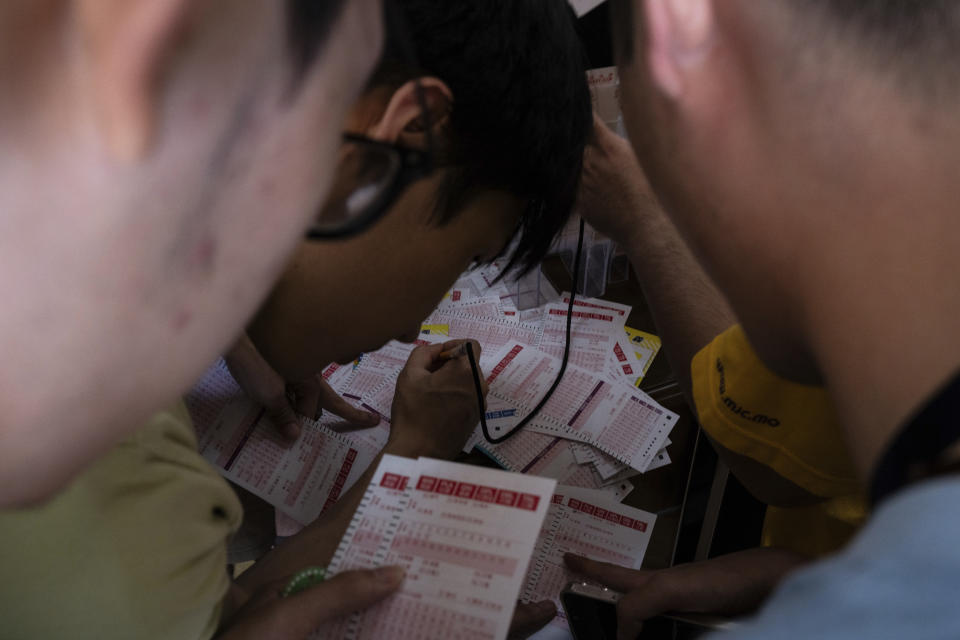 Visitors fill place their bets at the Macao Jockey Club in Macao, Saturday, March 30, 2024. After more than 40 years, Macao’s horse racing track hosted its final races on Saturday, bringing an end to the sport in the city famous for its massive casinos. (AP Photo/Louise Delmotte)