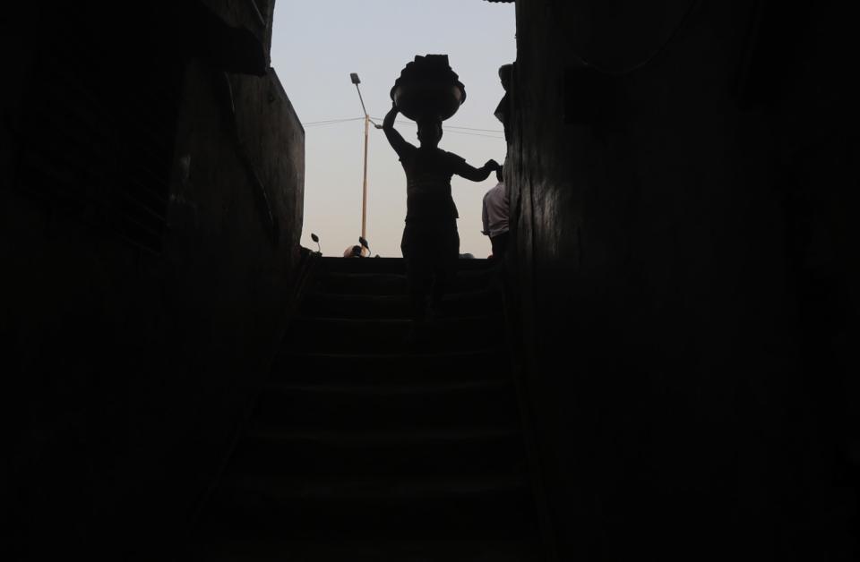 A worker carries a load of bricks