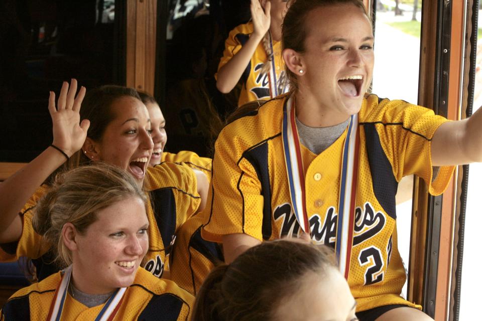 Naples High School outfielder Lauren Trembly, Julia Szilagyi, and third baseman Katie Raile, clockwise from lower left, bask in the celebration of their state championship title from a Naples Trolly Tours bus down Fifth Avenue on Wednesday, May 21, 2008.