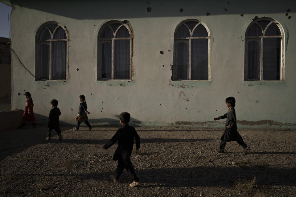 Afghan children play outside a mosque covered by bullet holes at a village in Sayedabad district, Wardak province, Afghanistan, Monday, Oct. 11, 2021. In urban centers, public discontent toward the Taliban is focused on threats to personal freedoms, including the rights of women. In Salar, these barely resonate. The ideological gap between the Taliban leadership and the rural conservative community is not wide. Many villagers supported the insurgency and celebrated the Aug. 15 fall of Kabul which consolidated Taliban control across the country. (AP Photo/Felipe Dana)