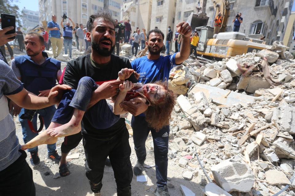 Susie, 7, is pulled from the rubble after the 16 May bombardment (Anadolu Agency via Getty)