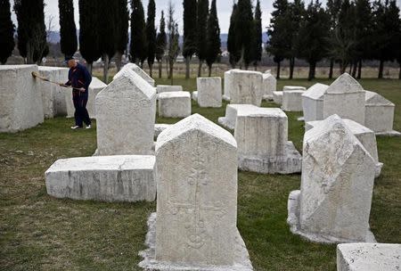 A worker cleans a tombstone at Radimlja necropolis near Stolac, March 10, 2015. REUTERS/Dado Ruvic/Files