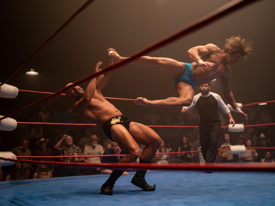 Zac Efron doing a drop kick in a wrestling ring