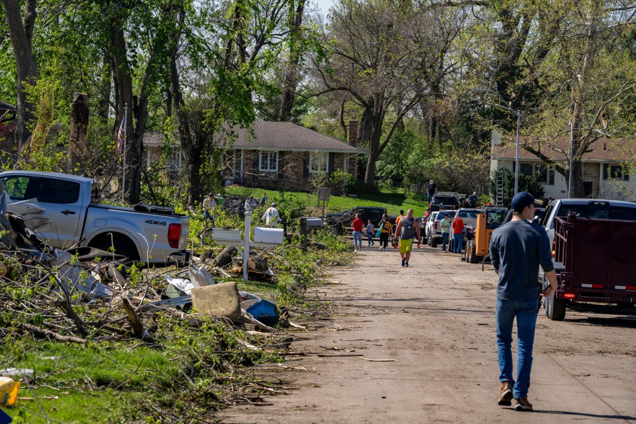 Residents clean up debris in Pleasant Hill on Saturday after multiple tornadoes ripped across the state Friday evening.