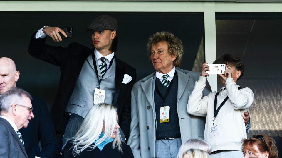 Alastair Stewart with Rod Stewart and Aiden Stewart at a football match; Alastair and Aiden are taking photos