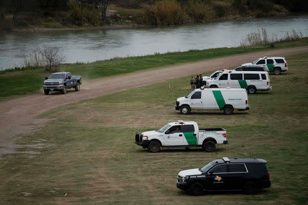 U.S. border patrol vehicles, seen through the fence of the bridge (not pictured) connecting Eagle Pass, Texas, with Piedras Negras, Mexico, are stationed near the banks of Rio Bravo as seen from Piedras Negras, February 8, 2019. REUTERS/Alexandre Meneghini