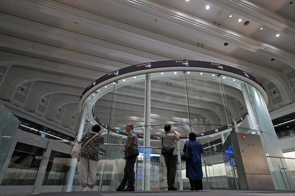 FILE - Visitors are seen in Tokyo Stock Exchange on Aug. 18, 2023 in Tokyo. Asian shares advanced Friday, with solid gains for Chinese markets after the central bank eased the reserve requirements for banks to encourage more lending and prop up the slowing economy. (AP Photo/Shuji Kajiyama, File)