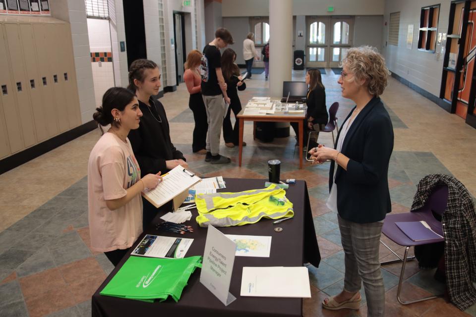 Patricia Williamson, right, of Consumers Energy talks with Tecumseh High School freshmen Balsam Marogi and Leila Morris about project management during the Career Exploration Fair Wednesday at the school.