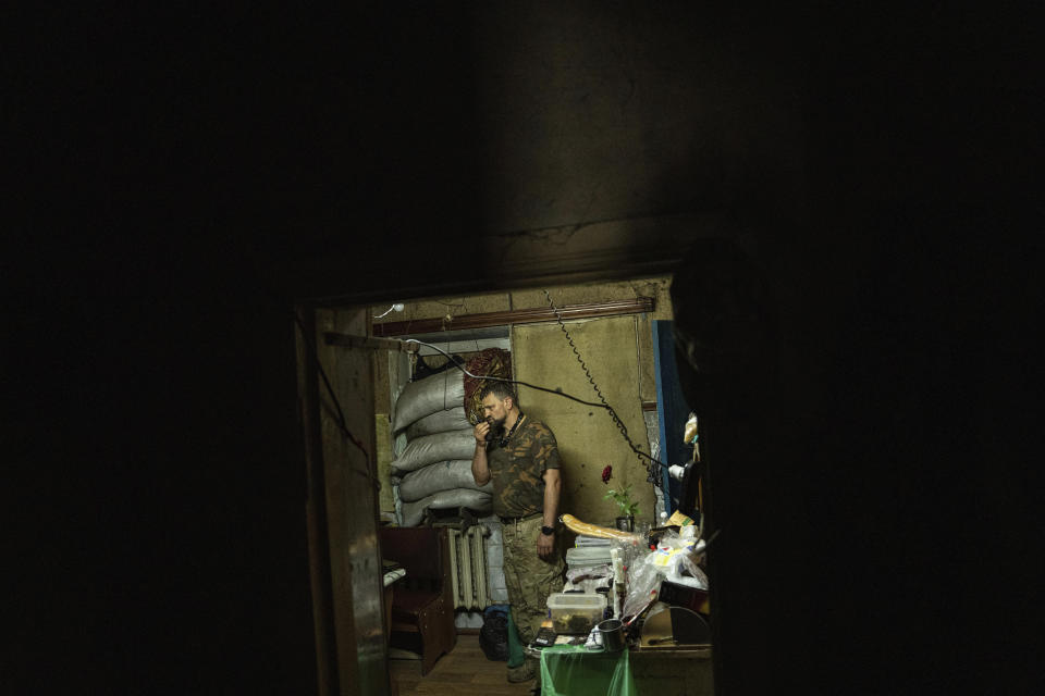 A Ukrainian serviceman, aka Yeti, of the 68th Oleksa Dovbush hunting brigade communicates by radio in the recently retaken village of Blahodatne, Ukraine, Saturday, June 17, 2023. (AP Photo/Evgeniy Maloletka)