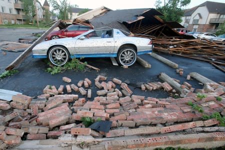 A car sits damaged when the garage it was parked in collapsed after a tornado touched down overnight in Trotwood, Ohio