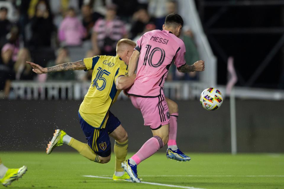 Real Salt Lake defender Justen Glad challenges Lionel Messi as he attempts to shoot the ball.