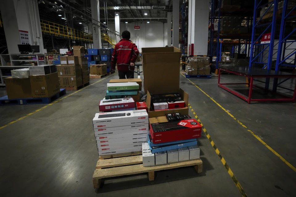 A worker pulls a trolley loaded with computer accessories at the Chinese online retailer JD.com's warehouse in Beijing on Tuesday, Nov. 9, 2021. China's biggest online shopping day, known as "Singles' Day" on Nov. 11, is taking on a muted tone this year as regulators crack down on the technology industry and President Xi Jinping pushes for "common prosperity." (AP Photo/Andy Wong)