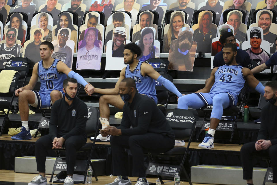 Villanova's Cole Swider (10) Caleb Daniels, center, and Eric Dixon (43) hold hands on the bench during an NCAA college basketball game against Providence in Providence, R.I., Saturday, March 6, 2021. Providence won, 54-52. (AP Photo/Stew Milne)