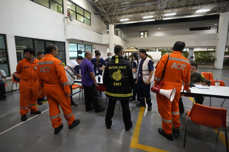 Members of a rescue team discuss after a London-Singapore flight was diverted to Bangkok due to severe turbulence, in Bangkok, Thailand, Tuesday, May 21, 2024. The plane apparently plummeted for a number of minutes before it was diverted to Bangkok, where emergency crews rushed to help injured passengers amid stormy weather, Singapore Airlines said Tuesday. (AP Photo/Sakchai Lalit)