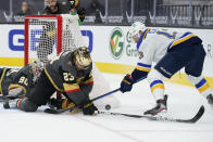 Vegas Golden Knights defenseman Alec Martinez (23) stops an attempted shot by St. Louis Blues left wing Kyle Clifford (13) during the third period of an NHL hockey game Friday, May 7, 2021, in Las Vegas. (AP Photo/John Locher)