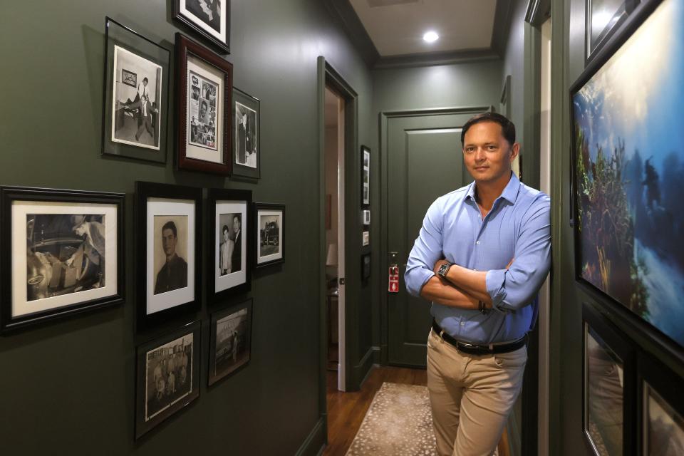 Best-selling Memphis author Mark  Greaney poses in front of a wall dedicated to his late father, Ed Greaney,  who spent close to 50 years at WMC-TV Channel 5, reaching the level of assistant general manager of news and public affairs.
