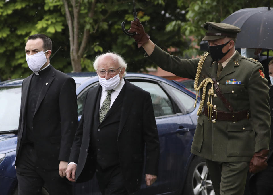 The President of Ireland Michael D Higgins, center, arrives to attend former Northern Ireland lawmaker and Nobel Peace Prize winner John Hume's funeral Mass at St Eugene's Cathedral in Londonderry, Northern Ireland, Wednesday, Aug. 5, 2020. Hume was co-recipient of the 1998 Nobel Peace Prize with fellow Northern Ireland lawmaker David Trimble, for his work in the Peace Process in Northern Ireland. Higgins is wearing a mask due ti the ongoing outbreak of the Coronavirus. (AP Photo/Peter Morrison)