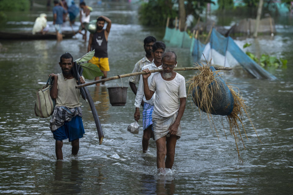 Flood affected people walk to safer places from their marooned Tarabari village, west of Gauhati, in the northeastern Indian state of Assam, Monday, June 20, 2022. Authorities in India and Bangladesh are struggling to deliver food and drinking water to hundreds of thousands of people evacuated from their homes in days of flooding that have submerged wide swaths of the countries. The floods triggered by monsoon rains have killed more than a dozen people, marooned millions and flooded millions of houses. (AP Photo/Anupam Nath)