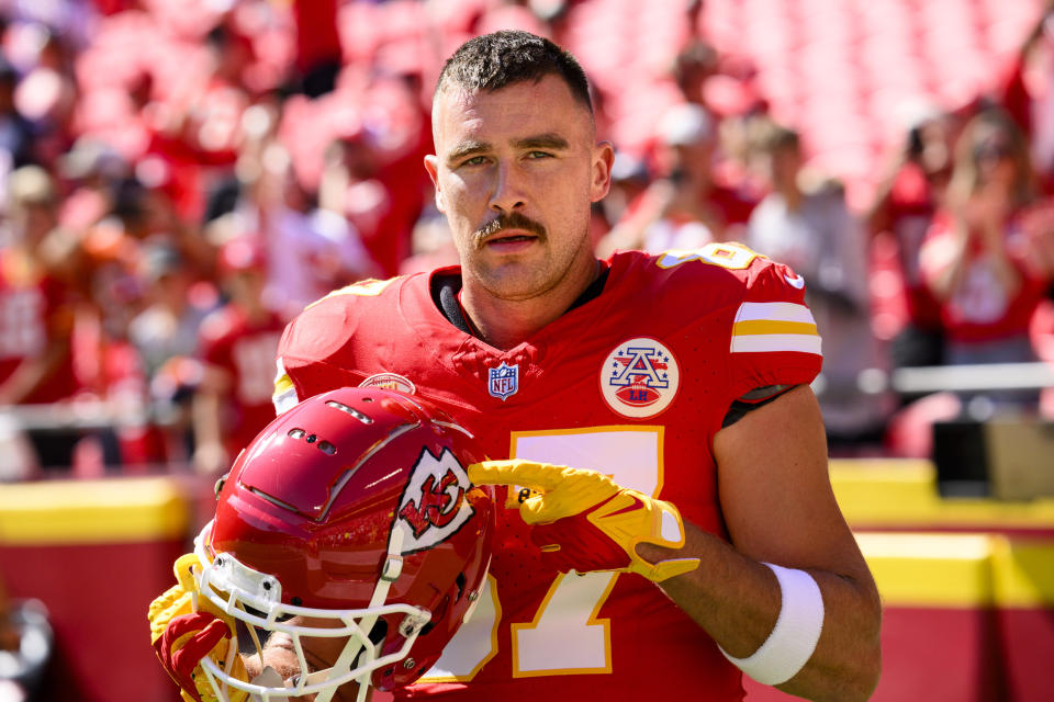 Kansas City Chiefs tight end Travis Kelce points to the Chiefs decal on his helmet as fans cheer during warmups before an NFL football game against the Chicago Bears, Sunday, Sept. 24, 2023 in Kansas City, Mo. (AP Photo/Reed Hoffmann)