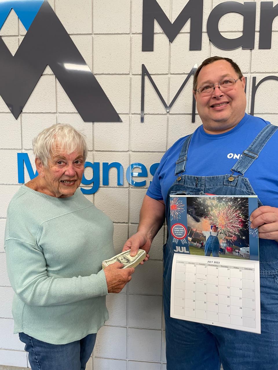Alice Fork receives funds from Matt Hammer at Martin Marietta, where Hammer works. He collected donations from a calendar from a calendar fundraiser to aid the Good Samaritan Council.