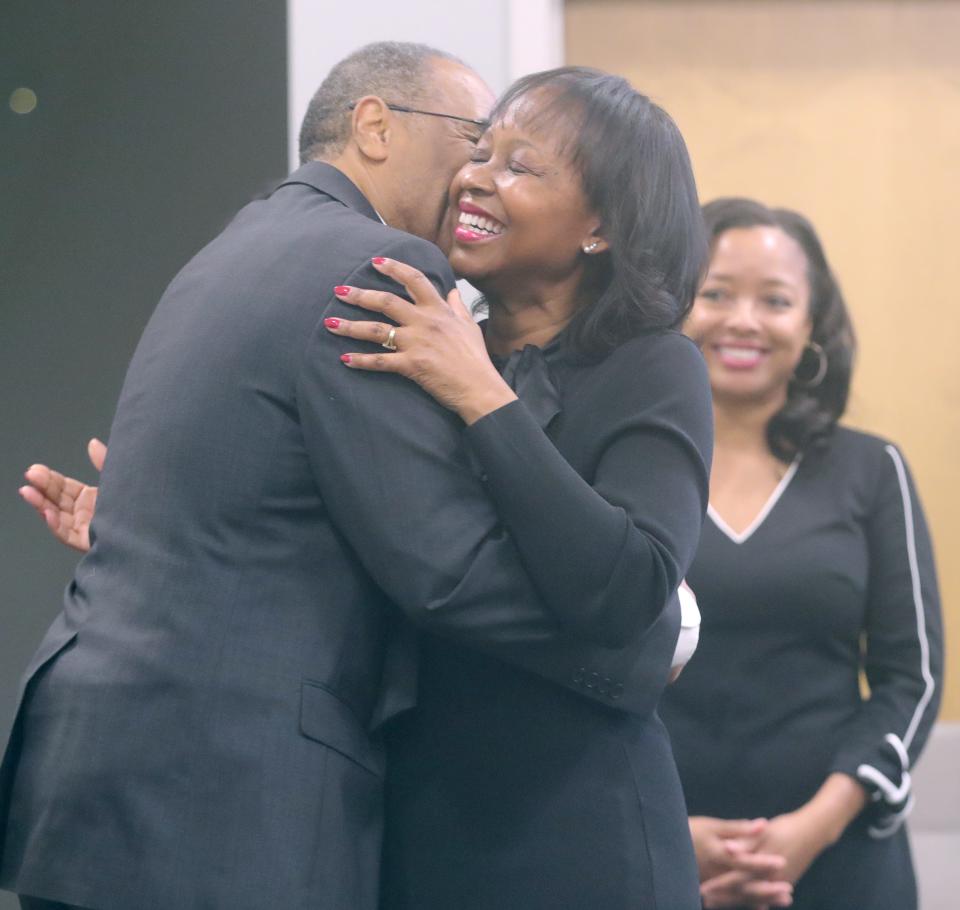New Akron Public Schools board member Barbara Sykes gets a kiss from her husband, Ohio Sen. Vernon Sykes, after she takes the oath of office from him Thursday at the district's administration building.