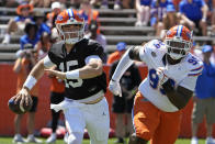 Florida quarterback Graham Mertz, left, looks for a receiver as defensive lineman Cam Jackson puts on pressure during the NCAA college football team's spring game, Saturday, April 13, 2024, in Gainesville, Fla. (AP Photo/John Raoux)