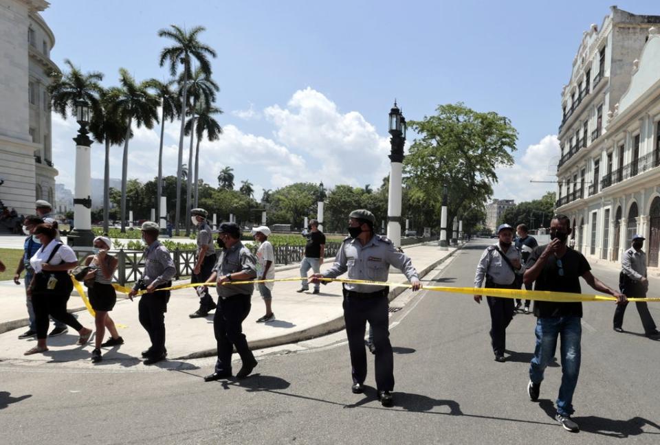 Members of the police move people away from the area where an explosion was registered at the Hotel Saratoga, in Havana, Cuba, 6 May 2022 (EPA)