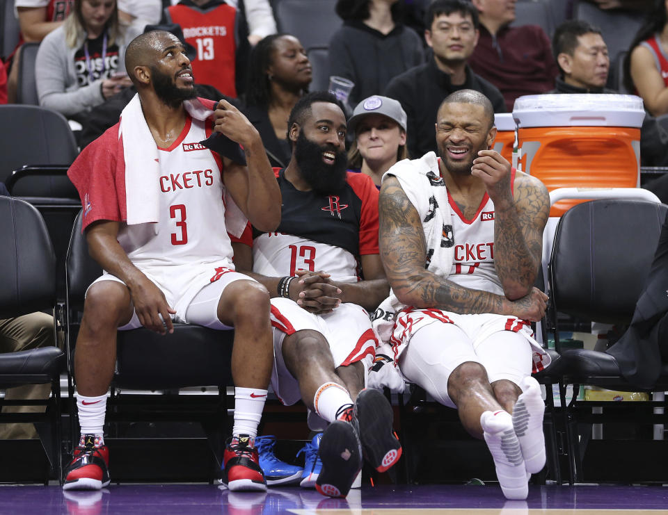 Houston Rockets' Chris Paul, left, James Harden, center and P.J. Tucker relax on the bench during closing moments of the team's 127-101 win over the Sacramento Kings in an NBA basketball game Wednesday, Feb. 6, 2019, in Sacramento, Calif. (AP Photo/Rich Pedroncelli)