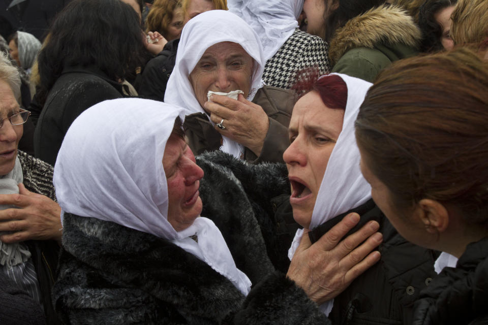 Ethnic Albanian woman weep during the funeral ceremony of 19 ethnic Albanians killed during 1998-99 Kosovo war in the town of Mala Krusa on Wednesday, March 26, 2014. The victims were killed in two separate rampages by Serbs forces in town of Suva Reka and Mala Krusa just days after NATO began a bombing campaign to end an onslaught by Serbia on separatist ethnic Albanians. (AP Photo/Visar Kryeziu)