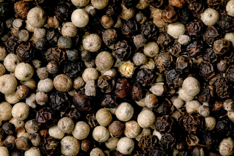 Close up of mix of black and white peppercorns.