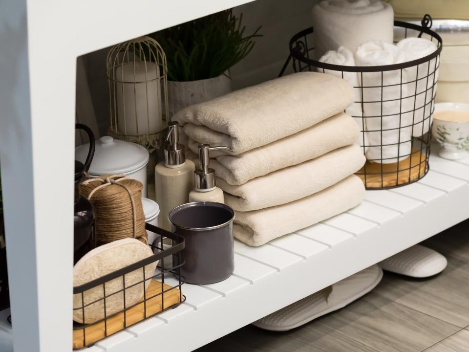 Very organized bathroom shelf with several towels