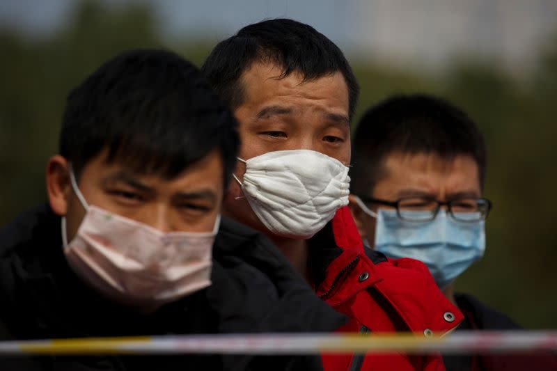 People coming from the Hubei province wait at a checkpoint at the Jiujiang Yangtze River Bridge in Jiujiang