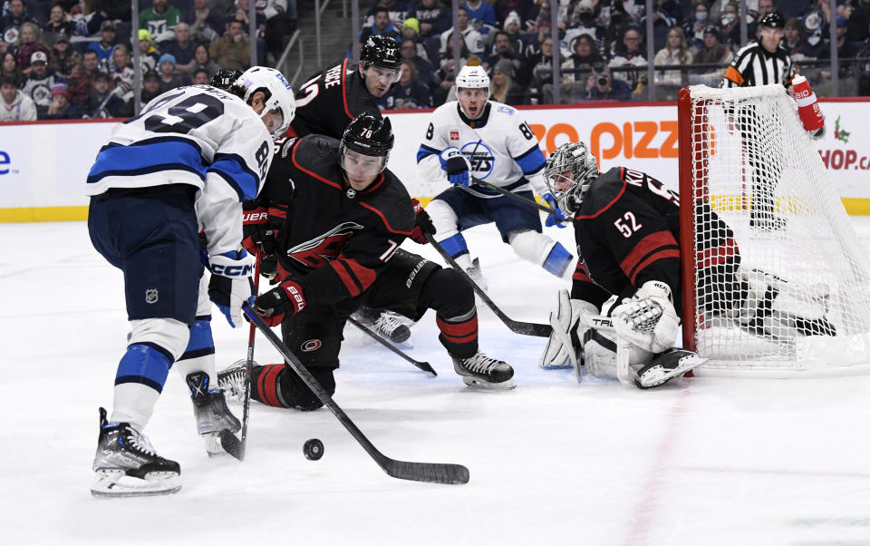 Carolina Hurricanes' Brady Skjei defends as Winnipeg Jets' Sam Gagner tires to get a shot on goaltender Pyotr Kochetkov during the second period of an NHL hockey game in Winnipeg, Manitoba, Monday, Nov. 21, 2022. (Fred Greenslade/The Canadian Press via AP)