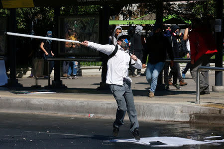 A demonstrator clashes with riot police during a protest demanding an end to profiteering in the education system in Santiago, Chile April 19, 2018. REUTERS/Rodrigo Garrido