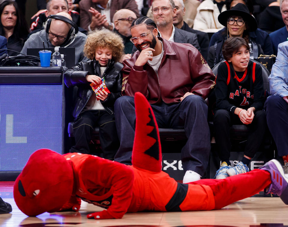 <p>The Toronto Raptors' mascot hits the floor at the team's home-court game on Dec. 7, much to the delight of <a href="https://people.com/tag/drake/" rel="nofollow noopener" target="_blank" data-ylk="slk:Drake;elm:context_link;itc:0;sec:content-canvas" class="link ">Drake</a> and his 5-year-old <a href="https://people.com/parents/drake-and-son-adonis-watch-raptors-lakers-game-from-courtside-perch/" rel="nofollow noopener" target="_blank" data-ylk="slk:son, Adonis;elm:context_link;itc:0;sec:content-canvas" class="link ">son, Adonis</a>.</p>