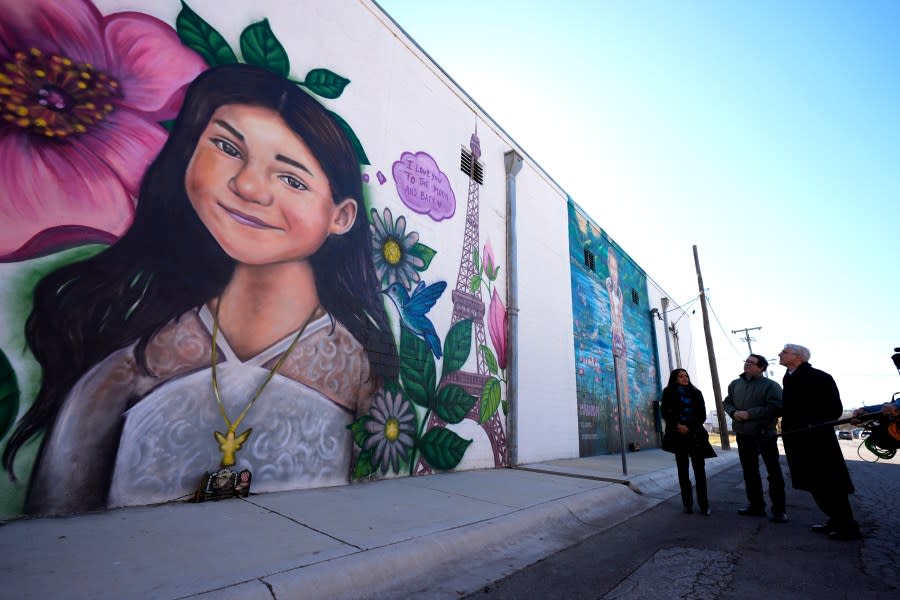 Artist Abel Ortiz, second from right, gives Attorney General Merrick Garland, right, and Associate Attorney General Vanita Gupta, left, a tour of murals of shooting victims, Wednesday, Jan. 17, 2024, in Uvalde, Texas. The Justice Department is planning this week to release findings of an investigation into the 2022 school shooting. (AP Photo/Eric Gay)