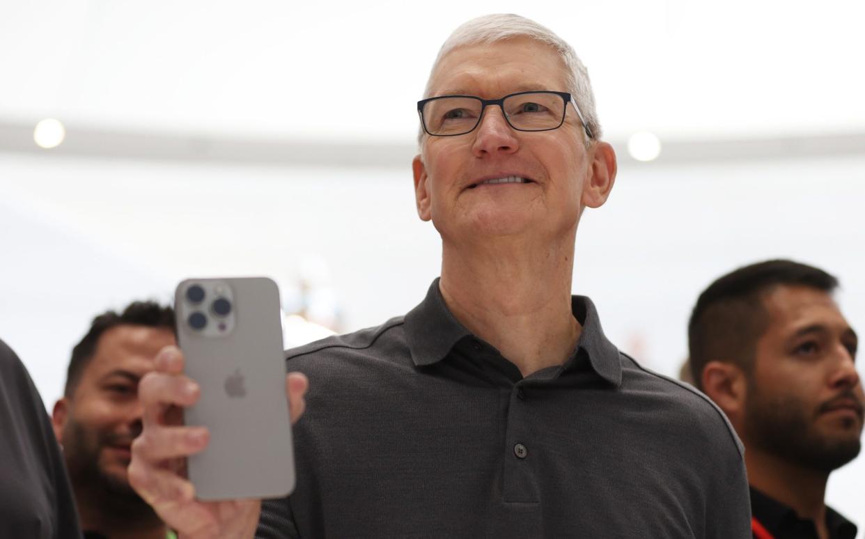 Apple chief Tim Cook holds up an iPhone 15 Pro last September at an event in Cupertino, California