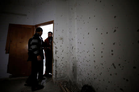 People stand in a damaged house where a Palestinian gunman was killed by Israeli forces, near Nablus in the Israeli-occupied West Bank December 13, 2018. REUTERS/Abed Omar Qusini